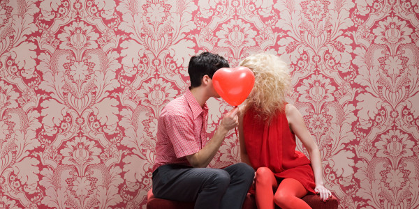 Couple behind heart shaped balloon