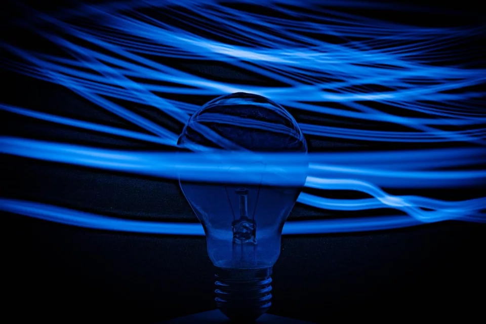 A lightbulb is surrounded by blue lights.